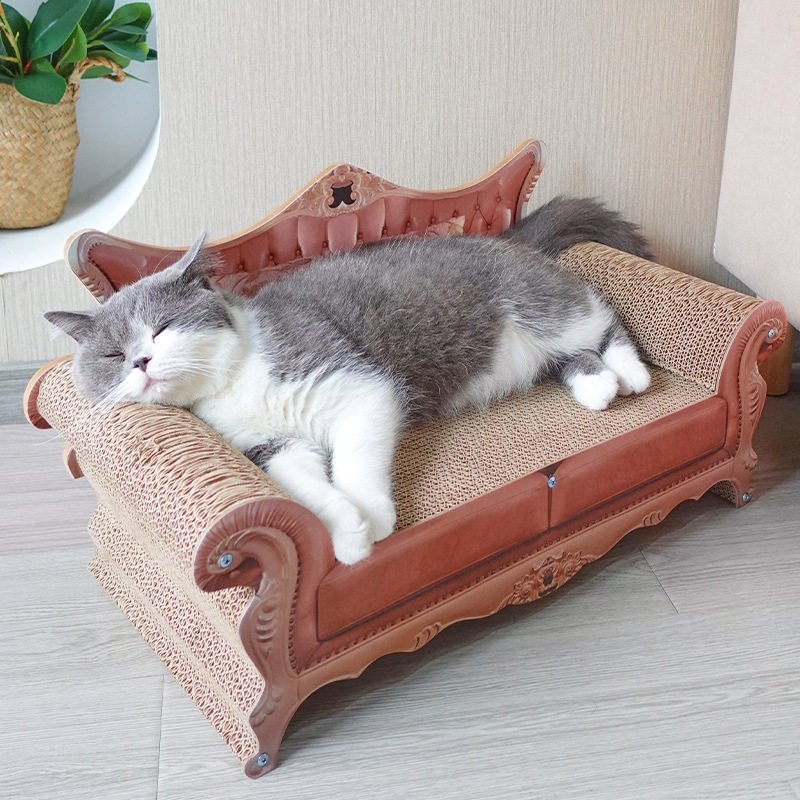 Grey and white cat on a bed-shaped corrugated cardboard scratching board
